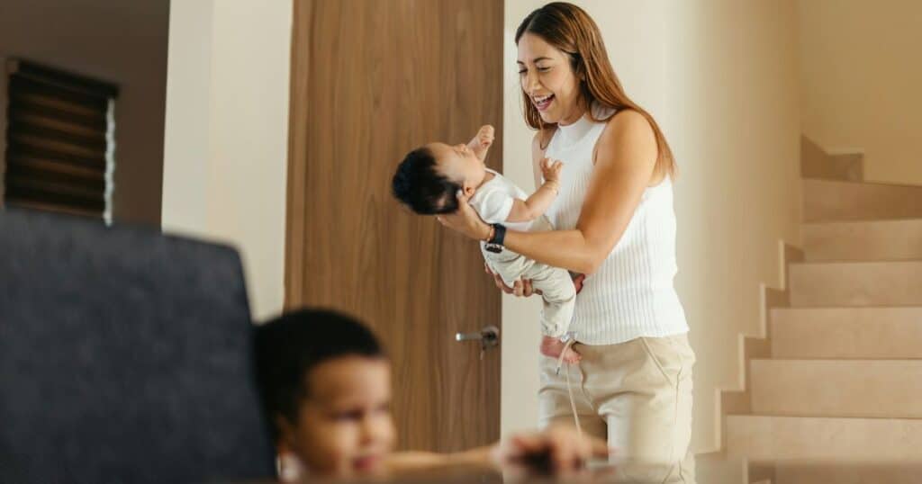 New mom with newborn and sibling during postpartum babymoon at home