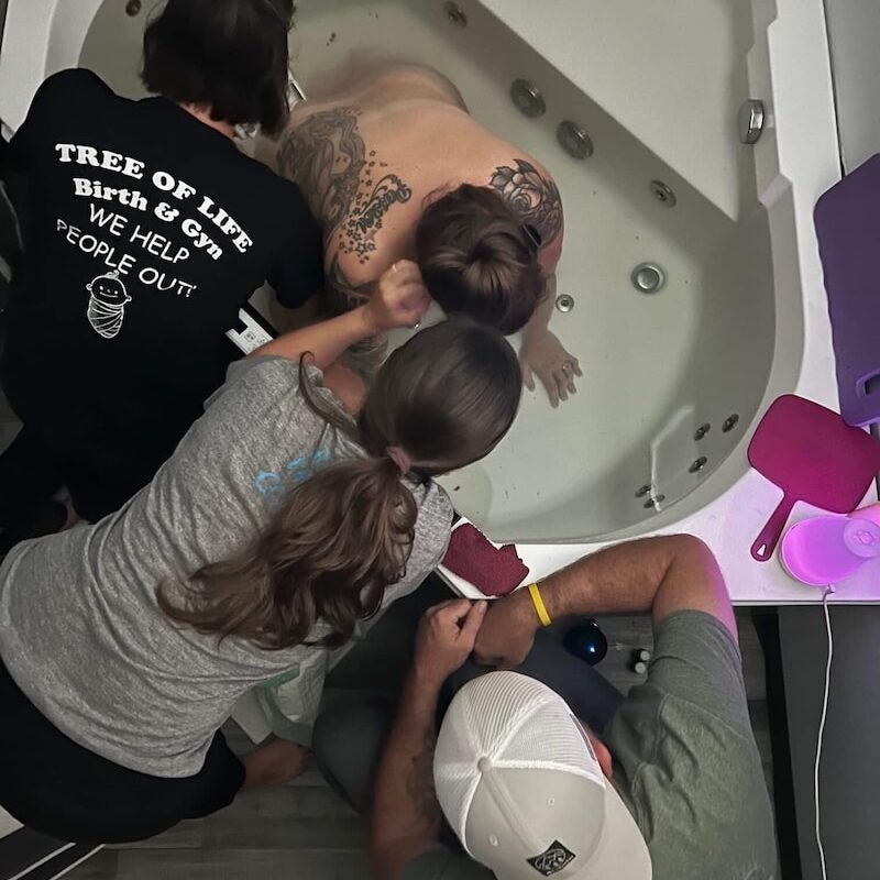 Woman birthing in tub at birth center